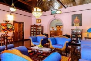 a living room with blue chairs and a table at Chiramel Residency in Cochin