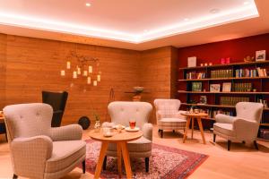 hotel & chalet madlochBlick في ليش ام ارلبرغ: مكتبة فيها كراسي وطاولات ورفوف كتب