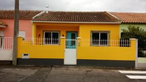 a yellow house with a blue door at Lost in Terceira in Angra do Heroísmo