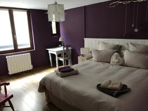 a bedroom with a large white bed and a desk at Les Authentics - La Maison d'Amélie in Riquewihr