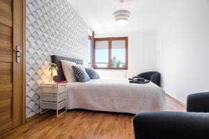 a white bedroom with a bed and a window at JT Apartments/Dworska in Krakow