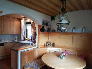 Fewo Alpenvorland في بيسينبيرغ: مطبخ مع طاولة خشبية وغرفة طعام