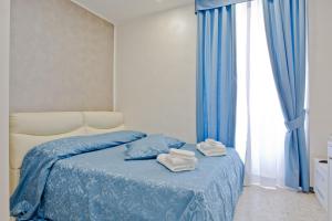 a bedroom with a bed with blue sheets and a window at Oscar 2 in Rome