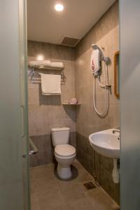 a bathroom with a toilet, sink, and shower at U Plus Budget Hotel in Bukit Mertajam