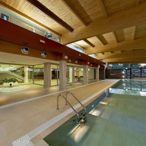 a swimming pool in a building with a wooden ceiling at Eureka Palace Hotel Spa Resort in Cassibile
