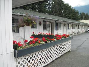 a white building with flowers in a window box at Alpine Motel in Hope