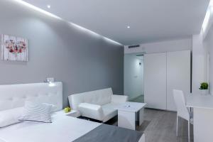 a white room with a bed and a couch and a table at Boutique Urban Madrid Serrano in Madrid