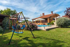 a yard with a swing and a house at Hacienda RoseMary in Muntić