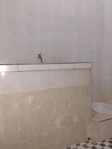 Baño de azulejos blancos con lavabo y aseo en Puri Garden Batu, en Batu