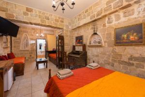 1 dormitorio con 2 camas en una habitación con pared de piedra en Spot Hotel, en Rodas