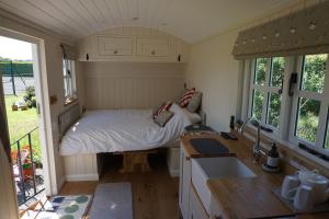 ein kleines Schlafzimmer mit einem Bett und einem Waschbecken darin in der Unterkunft Nutgrove House Luxury B&B in Seaforde