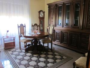 une salle à manger avec une table, des chaises et une horloge dans l'établissement S. Giorgio, à Tinnura