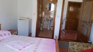 1 dormitorio con 1 cama y puerta al baño en Rooms Ajllin, en Ulcinj