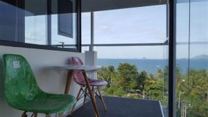 Habitación con 2 sillas, mesa y ventanas en Oasis Nha Trang Hotel, en Nha Trang
