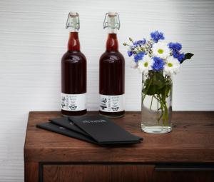une table avec deux bouteilles et un vase de fleurs dans l'établissement Araslöv Golf & Resort, à Kristianstad 23 autres photos