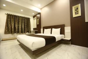 1 dormitorio con 1 cama grande en una habitación en Hotel Madhuri Executive, en Kolhapur