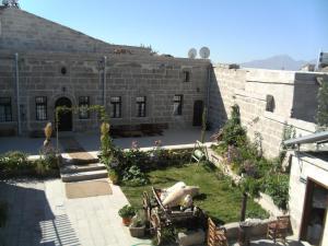 an old stone building with a garden with a cannon at Osmanoglu Hotel in Guzelyurt