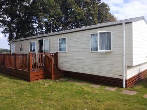 a mobile home with a porch and a fence at Warren View in Dawlish