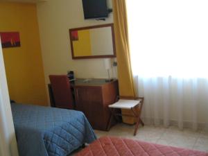 a bedroom with a desk and a bed and a mirror at Hotel San Martino in Cassibile