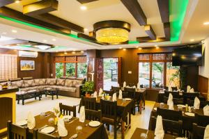 een restaurant met tafels, stoelen en een bank bij Hotel Romantica in Pokhara