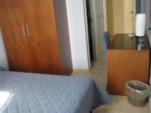 a bedroom with a bed and a wooden cabinet at Hotel San Martino in Cassibile