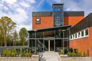 un bâtiment en brique rouge avec un panneau. dans l'établissement Almnäs Park Hotel, à Södertälje