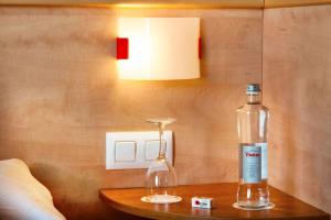 a bottle on a wooden table next to a lamp at Hotel Xaine Park in Lloret de Mar