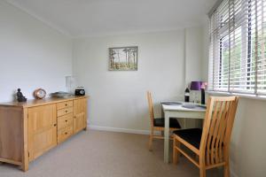 um quarto com uma secretária e uma mesa com cadeiras em Saurden Guest Apartment em Ipswich