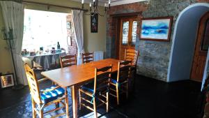 een eetkamer met een houten tafel en stoelen bij Knockaderry House in Ennis