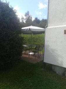 - une table et des chaises avec un parasol sur la terrasse dans l'établissement Chatka Ivanka, à Partizánska ľupča