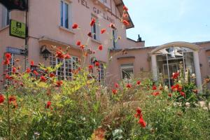 a building with red flowers in front of it at Logis Hotel Galland in Lapalisse