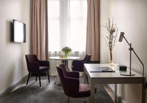 une chambre avec une table, des chaises et une fenêtre dans l'établissement Grand Hôtel Stockholm, à Stockholm