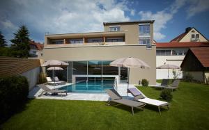 una casa con piscina y algunas sillas y sombrillas en Landhotel Weißes Roß, en Illschwang