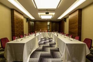 a long row of tables in a room with red chairs at Vista Hotel in Mezitli