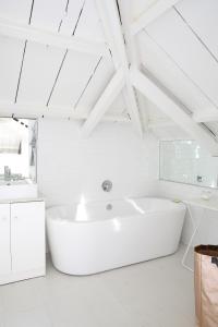Baño blanco con bañera y lavamanos en InAweStays Holiday Homes, en Ciudad del Cabo
