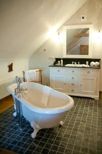 a white bath tub in a bathroom with a sink at De Pastory in Grote-Brogel