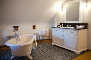 uma casa de banho com uma banheira branca e um lavatório. em De Pastory em Grote-Brogel