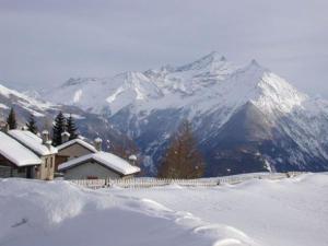 a house in the snow with mountains in the background at Le Petit Château de Vetan CIR 0023 in Saint-Pierre