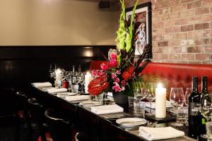a long table in a restaurant with candles and flowers at Malmaison Hotel Leeds in Leeds