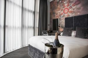 a bottle of champagne in a bucket next to a bed at Malmaison Hotel Leeds in Leeds