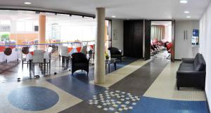 a lobby with chairs and tables in a building at Antonius Imperial Hotel in Santo Antônio de Jesus