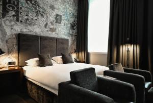 a hotel room with a bed and two chairs at Malmaison Hotel Leeds in Leeds