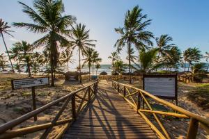 a wooden walkway to the beach with palm trees at Grand Palladium Imbassaí Resort & Spa - All Inclusive in Imbassai