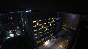 - une vue de tête sur un grand bâtiment la nuit dans l'établissement First Hotel, à Guri