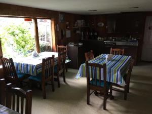 a dining room with two tables and chairs and a kitchen at Cave Mountain Motel in Windham