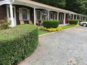a house with chairs and flowers in front of it at Cave Mountain Motel in Windham