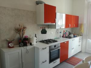 una cucina con armadi rossi e un piano cottura. di Treehouse a Pisa