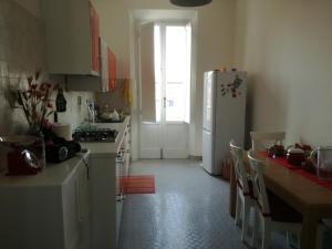 una cucina con frigorifero e tavolo con sedie di Treehouse a Pisa