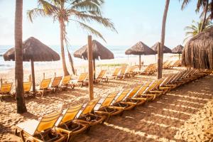 a row of chairs and umbrellas on a beach at Grand Palladium Imbassaí Resort & Spa - All Inclusive in Imbassai