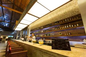 a bar with wine bottles on the wall at Grand Palladium Imbassaí Resort & Spa - All Inclusive in Imbassai